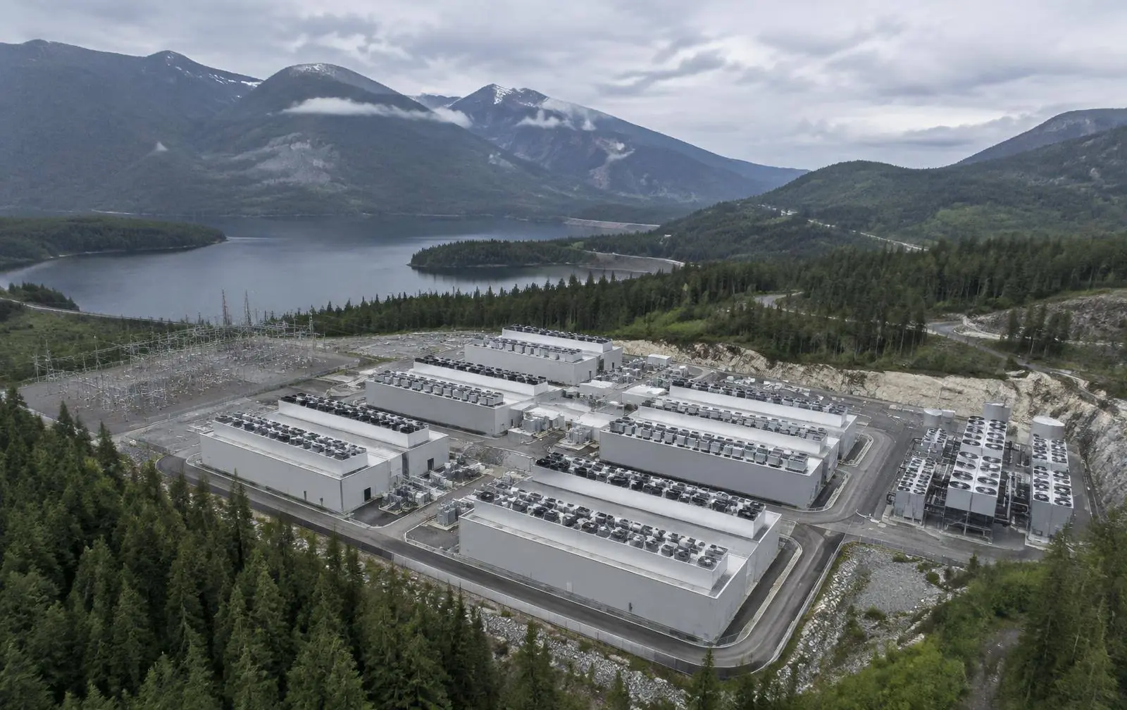 Aerial render of a green AI computing park in Canada with prefabricated halls and substation